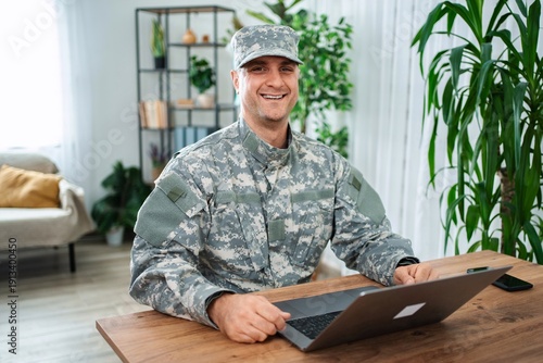 Wallpaper Mural Smiling soldier using laptop at home Torontodigital.ca