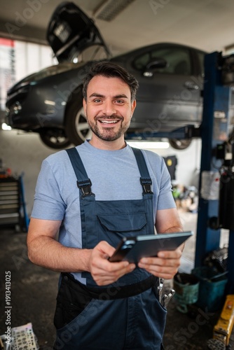 Wallpaper Mural Car mechanic using a digital tablet and smiling at the camera in Torontodigital.ca