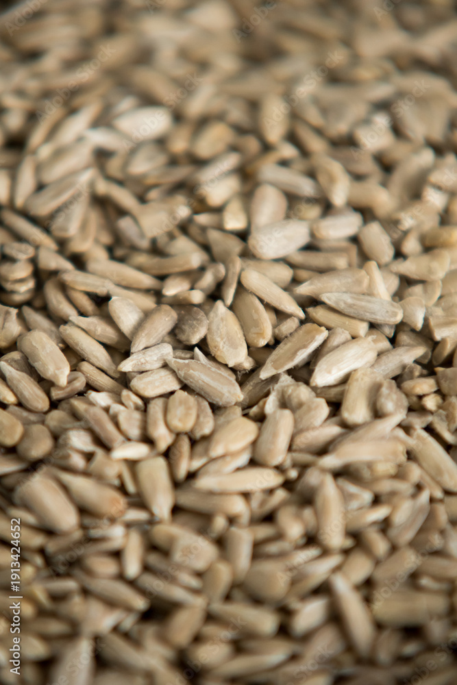 Obraz premium Peeled sunflower seeds vertical background. Healthy snack