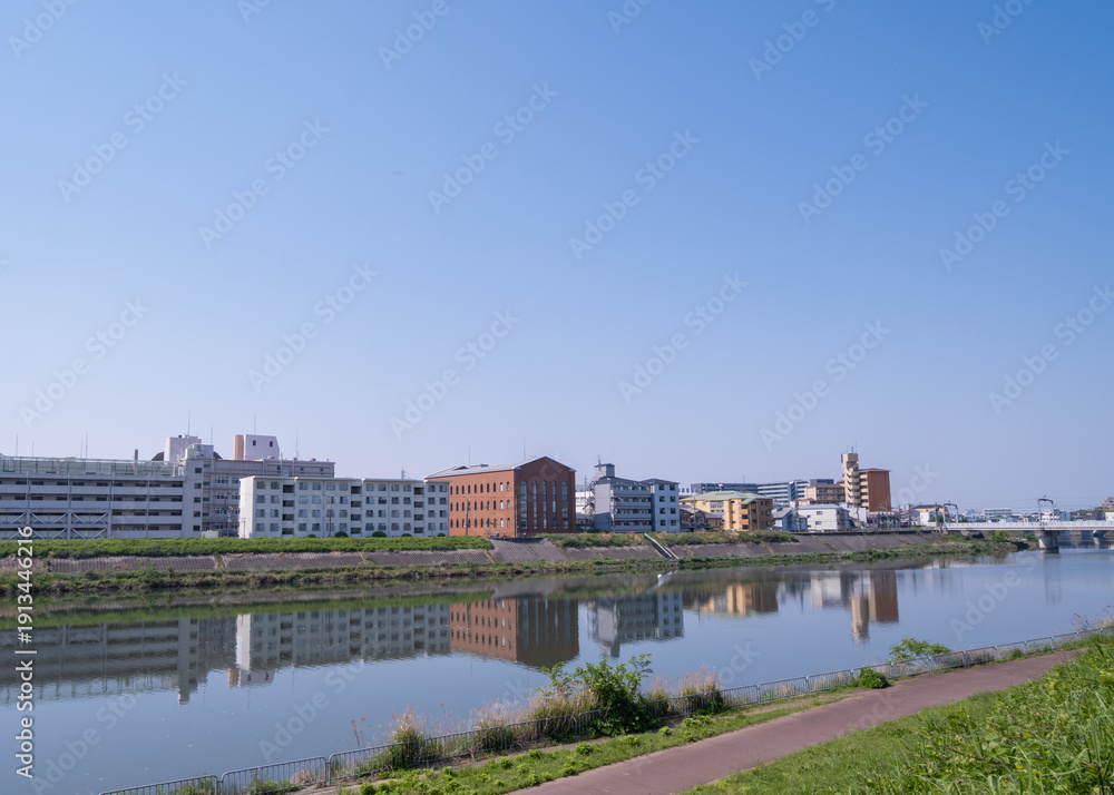 Obraz premium 川沿いに並ぶ街並みと水面の反射