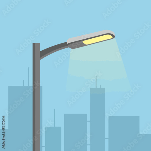 Streetlight illuminating city skyline at dusk