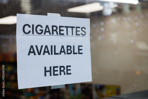 Φωτογραφία Sign reading CIGARETTES AVAILABLE HERE displayed on glass window of retail store