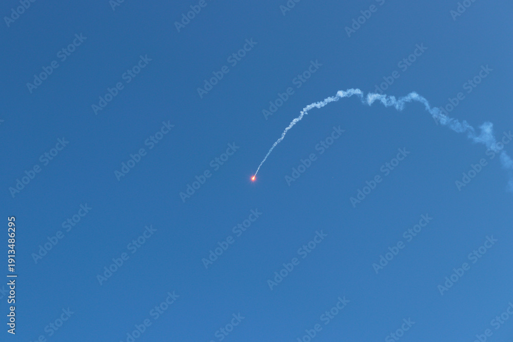 Fototapeta premium Launching rockets from the ground and burning in the sky. Low angle view of smoke in the sky.