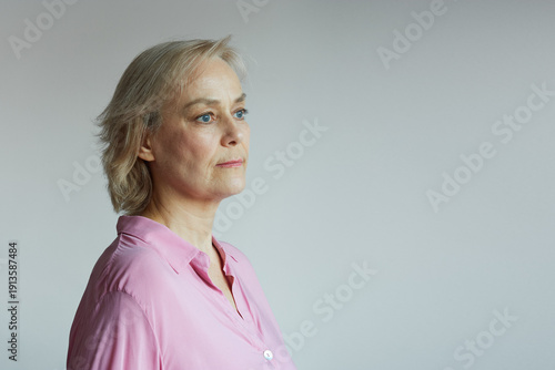 Portrait of a mature woman of 60 years old on a gray background, natural aging, natural beauty