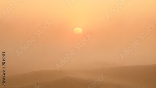 A serene desert landscape at sunset with a hazy orange sky and a setting sun over rolling sand dunes.