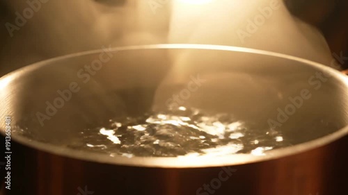 Boiling Water in Metal Pot with Steam Rising.