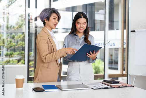 Foto Company executive coaching young personal secretary assistant, team leader or senior manager explaining work duties to junior