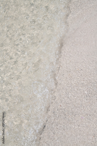 Transparent water in coastal sea for summer purity. Transparent water on seashore sand for texture. Transparent water in ripples for abstract calm. Transparent water on beach for clean copy space.
