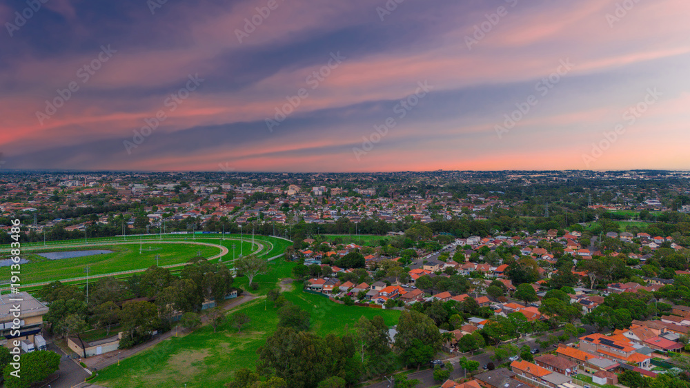 Fototapeta premium Panoramic Aerial Drone view of Inner Western Suburbs of Sydney housing, roof tops, the streets and the parks, the roads and trees of Ashbury Ashfield Burwood Summer Hill Canterbury and Campsie in Sydn