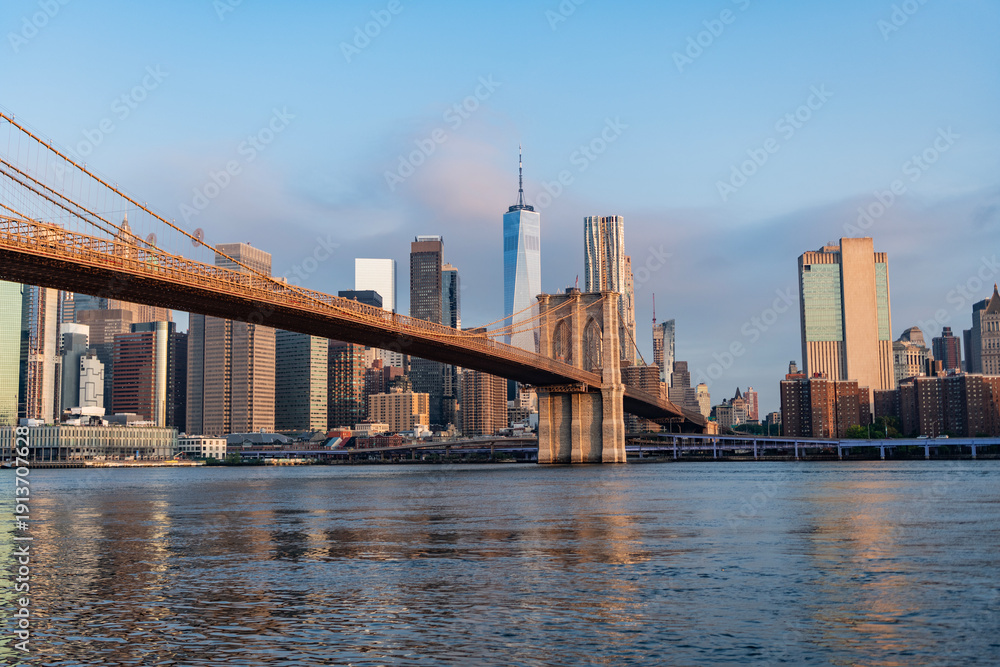 Fototapeta premium Brooklyn bridge of New York city. Brooklyn landmark. Urban panorama. Manhattan cityscape with skyscraper architecture. Brooklyn bridge to Manhattan. Urban architecture of New York city