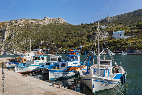 Small traditional fishing boats moored in the port of Rina at Vathy (Vathys) village on the island of Kalymnos in  Greece on a sunny day.