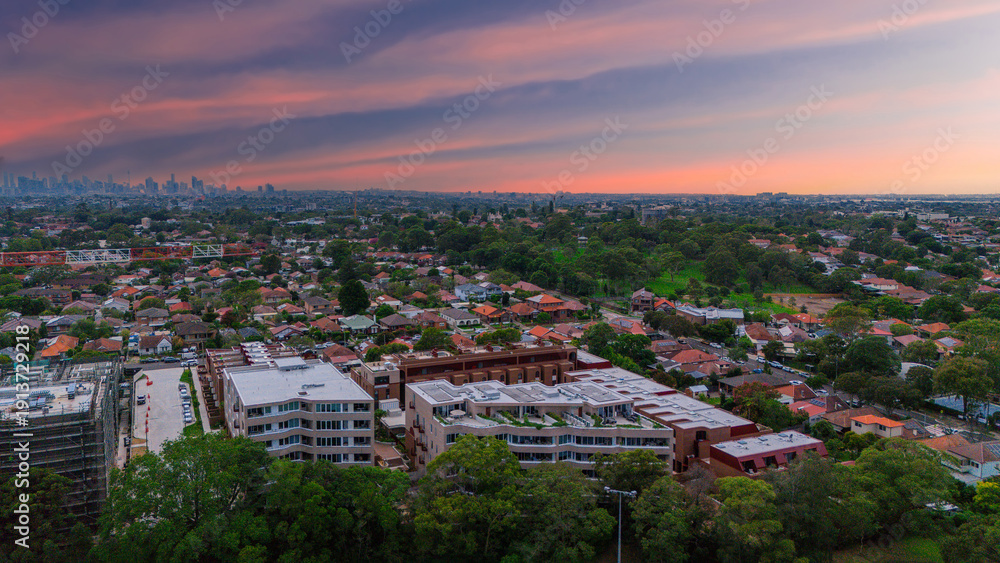 Fototapeta premium Panoramic Aerial Drone view of Inner Western Suburbs of Sydney housing, roof tops, the streets and the parks, the roads and trees of Ashbury Ashfield Burwood Summer Hill Canterbury and Campsie in Sydn