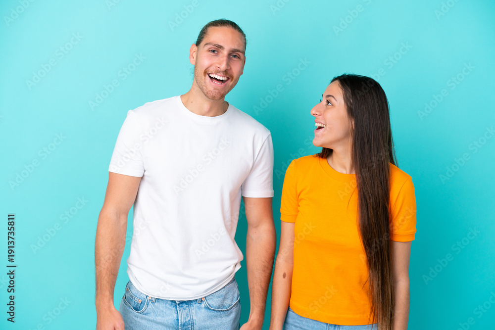 Fototapeta premium Young caucasian couple isolated on blue background with surprise facial expression