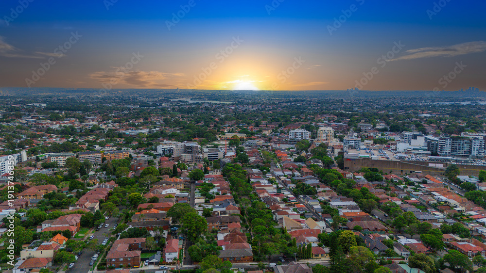 Obraz premium Panoramic Aerial Drone view of Inner Western Suburbs of Sydney housing, roof tops, the streets and the parks, the roads and trees of Ashbury Ashfield Burwood Summer Hill Canterbury and Campsie in Sydn