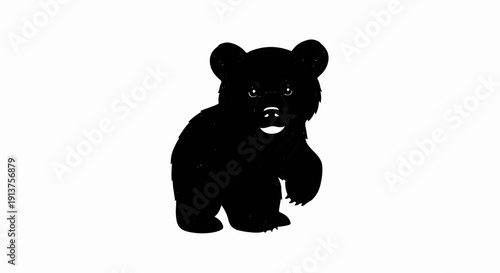 Black silhouette of a young bear cub standing and looking forward
