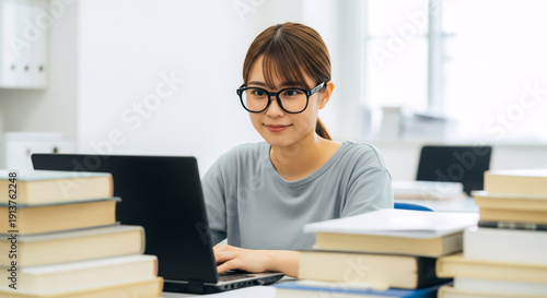 モダンなオフィスでノートパソコンを使う自信に満ちた若いビジネスウーマン。アジア人、日本人