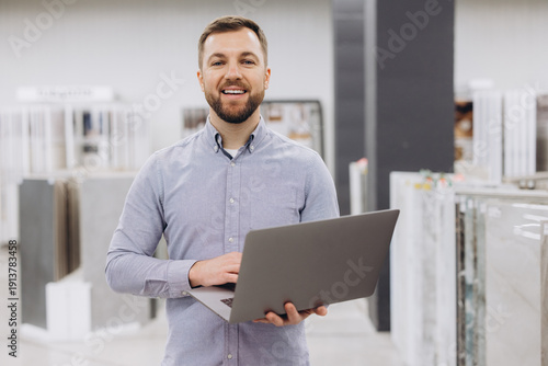 Konstfotografi Man smiling, using a laptop in a showroom