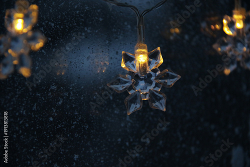 decorative snowflake light string on frosty window