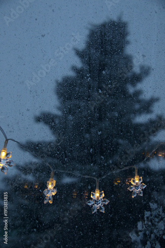 decorative snowflake light string on frosty window