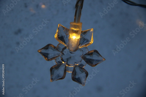 decorative snowflake light string on frosty window