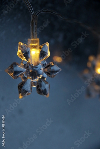 decorative snowflake light string on frosty window
