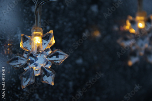 decorative snowflake light string on frosty window