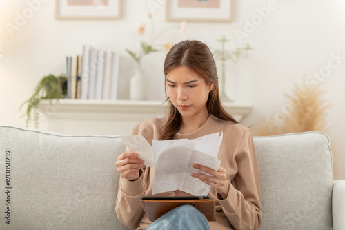 Asian woman feeling unhappy after looking bill feels stressed having financial problem, check finances, experiencing lack of money pay for loan, huge taxes, utility rates, get eviction notice.