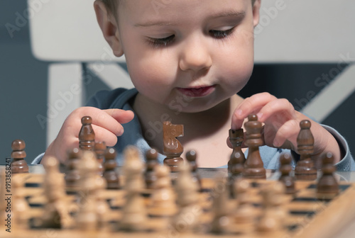 Canvas Print Future grandmaster carefully planning first chess move, proving strategic thinking can start before walking, talking, or understanding rules