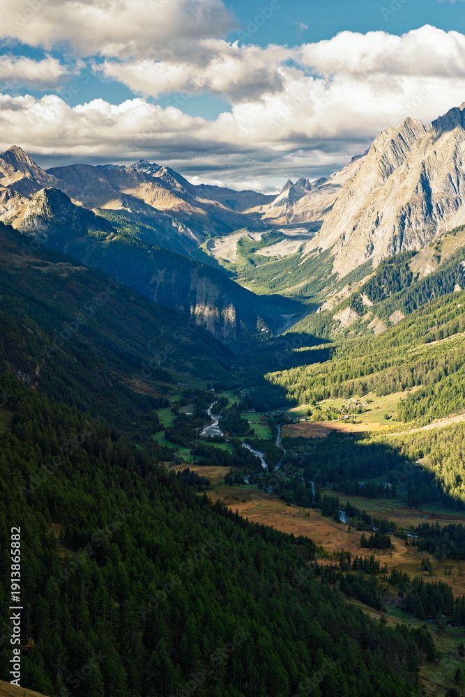 Fototapeta premium Val d'Aosta, Italy - August 15, 2025: High angle view of Val Veny valley and the debris-covered Miage Glacier under a dramatic sky on the Tour du Mont Blanc (TMB).