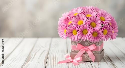 Pink daisies in a bouquet with a pink ribbon on a wooden table