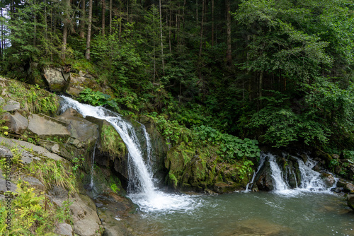 Mountain waterfall in the forest. Green nature background. Lake water fall river
