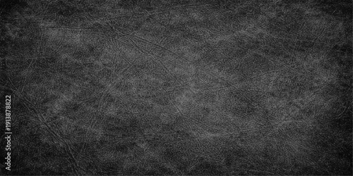 A dark and weathered black grunge background features an old textured stone surface with a rough vintage gray paper pattern for a blank dirty concrete backdrop design