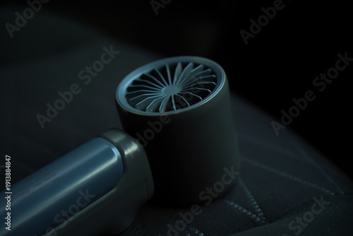 Close Up of a Small Portable Electric Fan for Car Ventilation Dark Interior Realistic Macro Shot