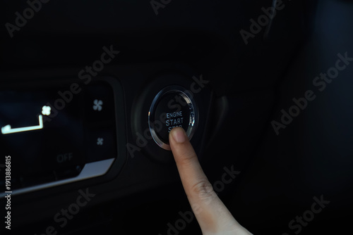 Finger Pressing Illuminated Engine Start Stop Button Inside Modern Car Interior With Digital Climate Control Panel