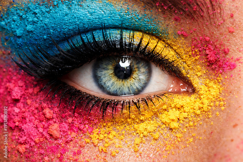 Vibrant eye makeup with colorful powder around blue eye