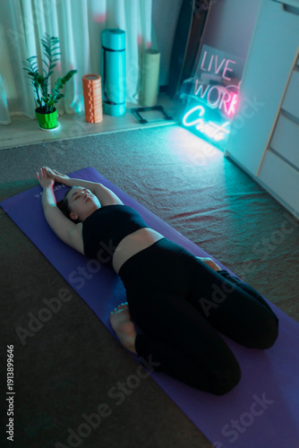 A young girl, beautiful woman practices yoga at home. Exercises for muscle toning, body stretching, and meditation. Self-care, beauty, youth, and health. Sport exercise and warm-up.