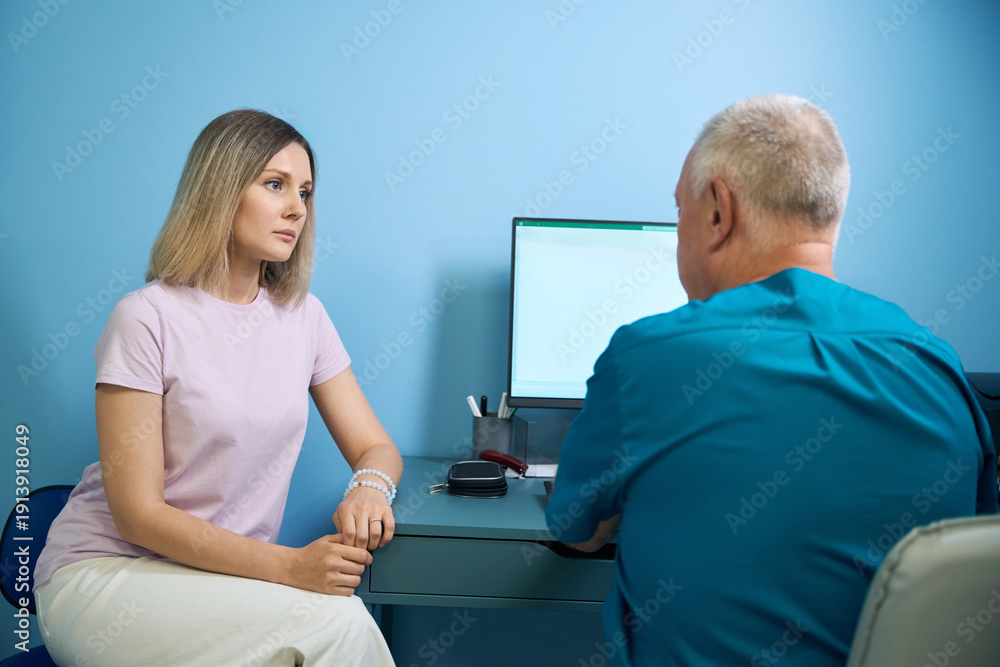 Obraz premium Male doctor ophthalmologist in discussion with female patient at medical clinic
