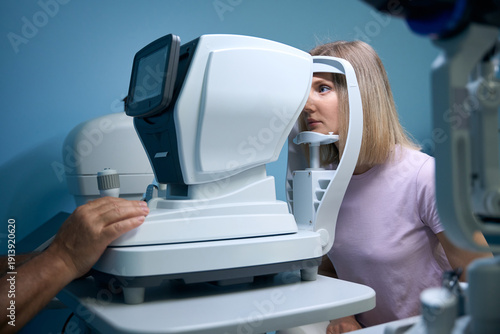 Young woman getting eye exam at ophthalmology clinic with optometrist