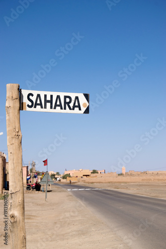 Sahara direction sign on desert road near Merzouga Morocco landscape