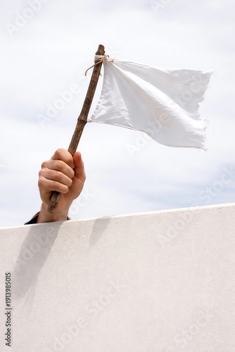 closeup photo of a man's hand holding a white flag