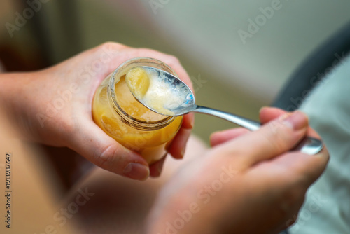 Wallpaper Mural Baby fruit puree on a metal teaspoon taken from a glass jar for infant feeding. Healthy baby nutrition concept. Torontodigital.ca