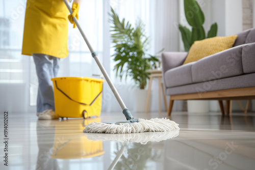 Professional cleaning service worker mops floor in modern apartment setting