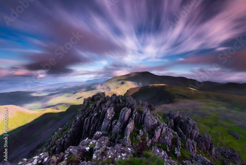 Rugged Mountain Peak with Vibrant Purple Star Trails Over Rolling Hills