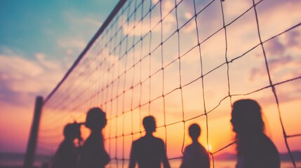 Group plays volleyball on beach at sunset, silhouettes against sky