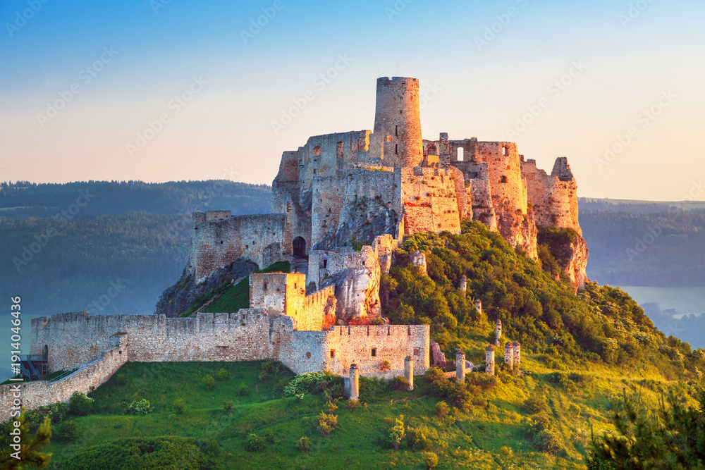 Obraz premium Spiš Castle (Spišský hrad) in Slovakia, a historic stone fortress perched on a hilltop, with panoramic views of the surrounding mountains. Dramatic sky, vibrant colors, and natural light highlight the