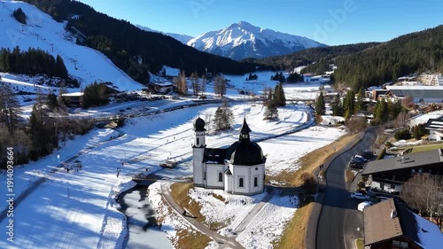 perspective sprawling alpine town seefeld mix modern hotels traditional chalets framed by majestic jagged limestone peaks karwendel wide drone tirol austria 