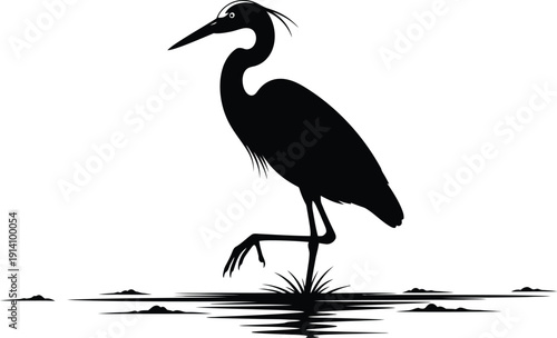 Heron silhouette stands poised in marshy water during a quiet morning.