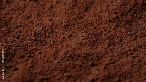 Natural dark brown cocoa powder textured background, close up, rotation. Heap of organic cacao powder