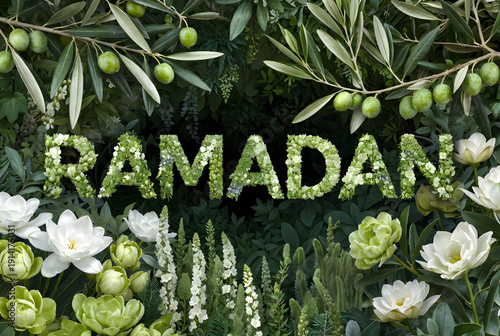 Lush green foliage and white flowers artfully spell out RAMADAN, celebrating peace and nature.