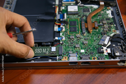 The technician is installing an M.2 hard drive.